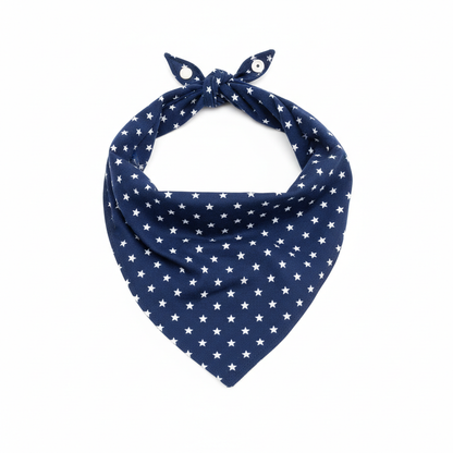 Navy blue star print pet bandana scarf with silver snap button closure, triangle shape, flat lay on white background