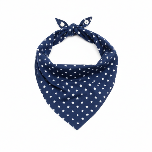 Navy blue star print pet bandana scarf with silver snap button closure, triangle shape, flat lay on white background
